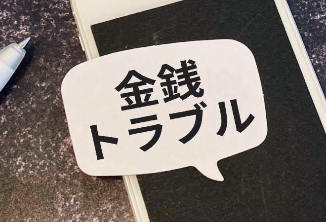 スマホの写真と金銭トラブルの文字が映っている画像、SNS上でグッズ交換しようとお金を振り込んだ相手に逃げられた状況のイメージ画像。