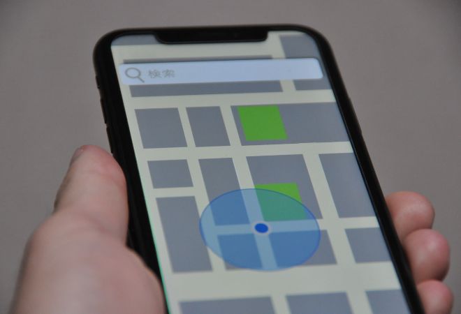 位置情報を見るために地図アプリで位置情報を開いている手元。