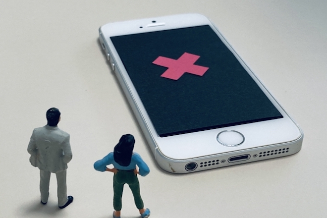 繋がらない電話を見つめる人たち。