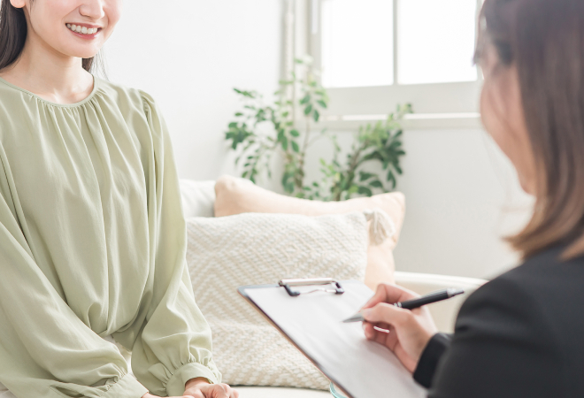 カウンセリングルームで話す女性とカウンセラー