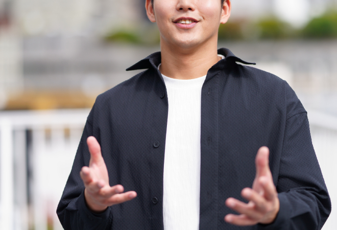 こちらに向かって微笑んで話しかけている男性。