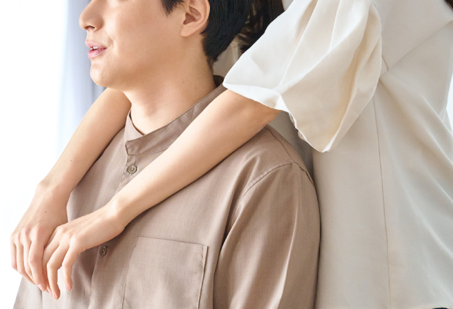 男性を後ろから抱きしめる女性。