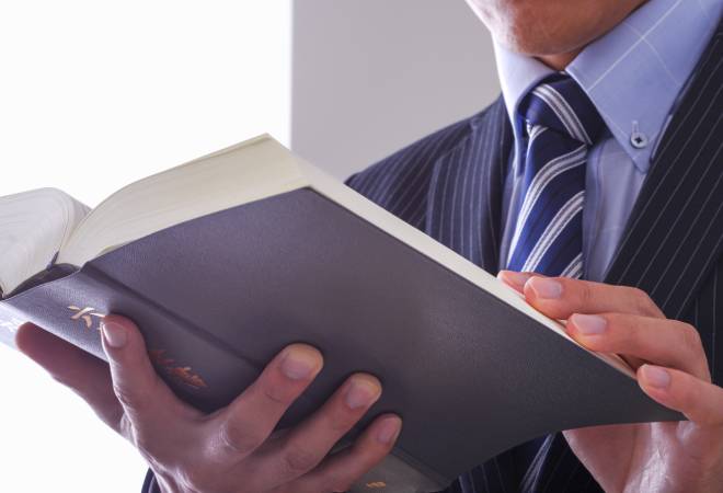 六法全書を見るスーツの男性。